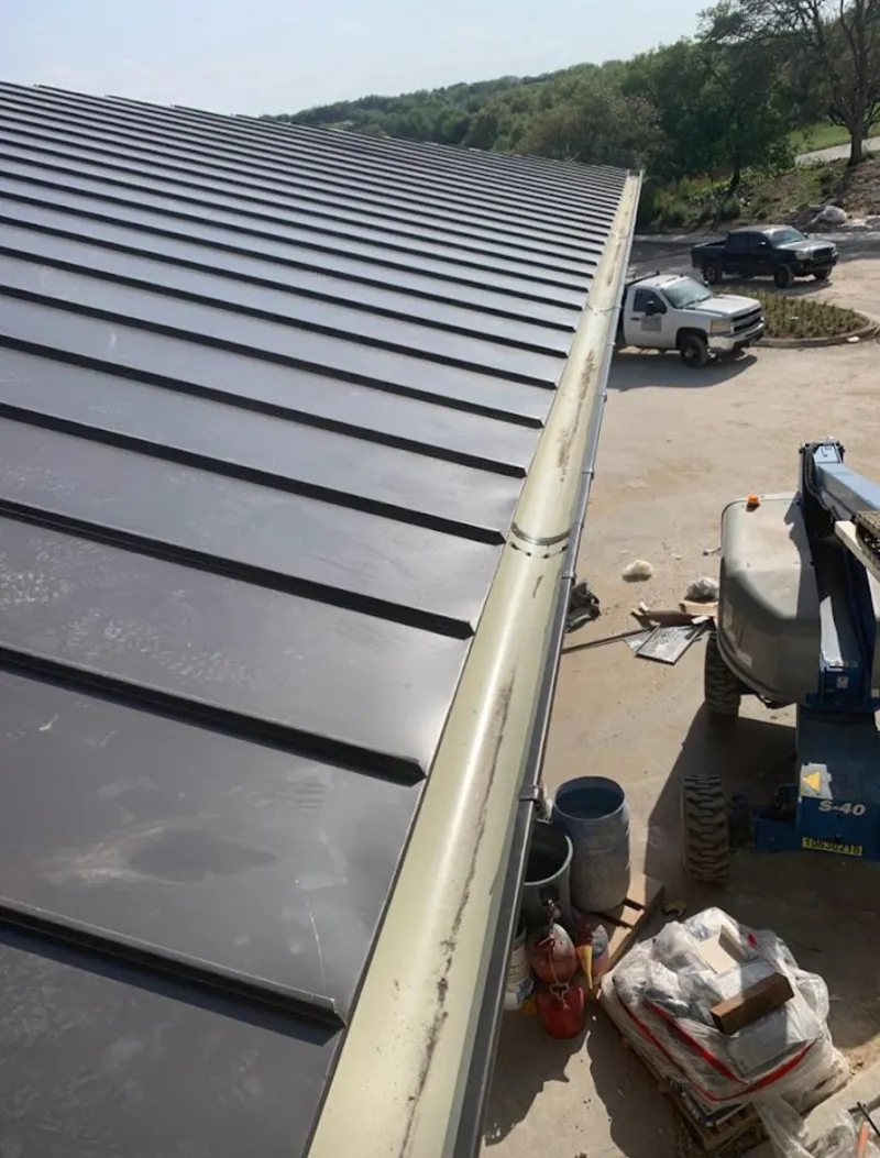 Standing seam panel and gutter detail on a metal roofing jobsite in Ashland City